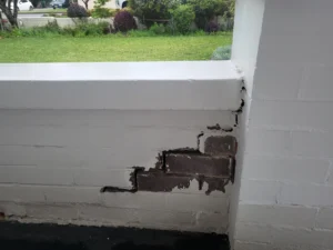 Brick wall fence showing cracks before repair